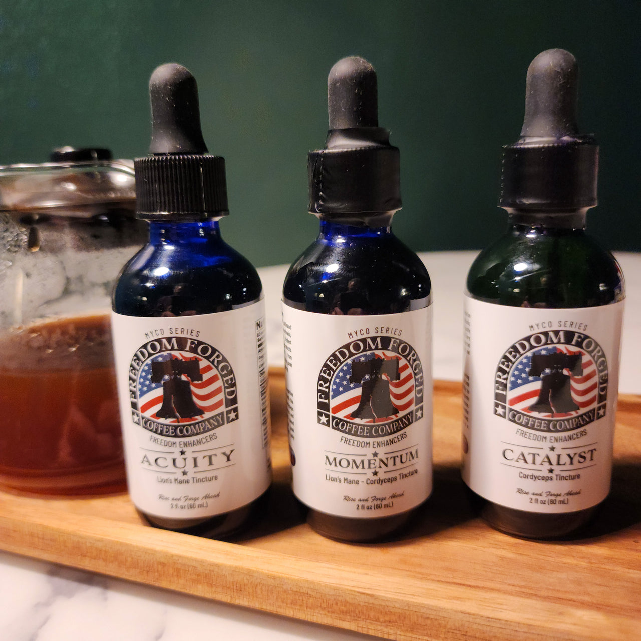 Three mushroom tincture bottles sitting on a wooden board.